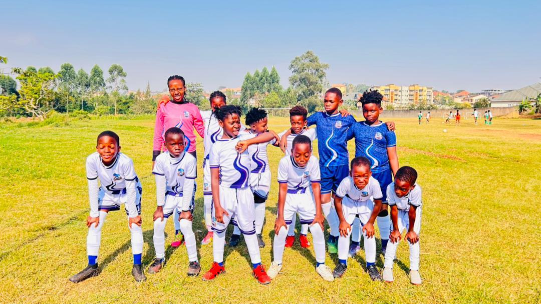 Young Source of Nile Academy footballers lined up on the pitch before kick-off